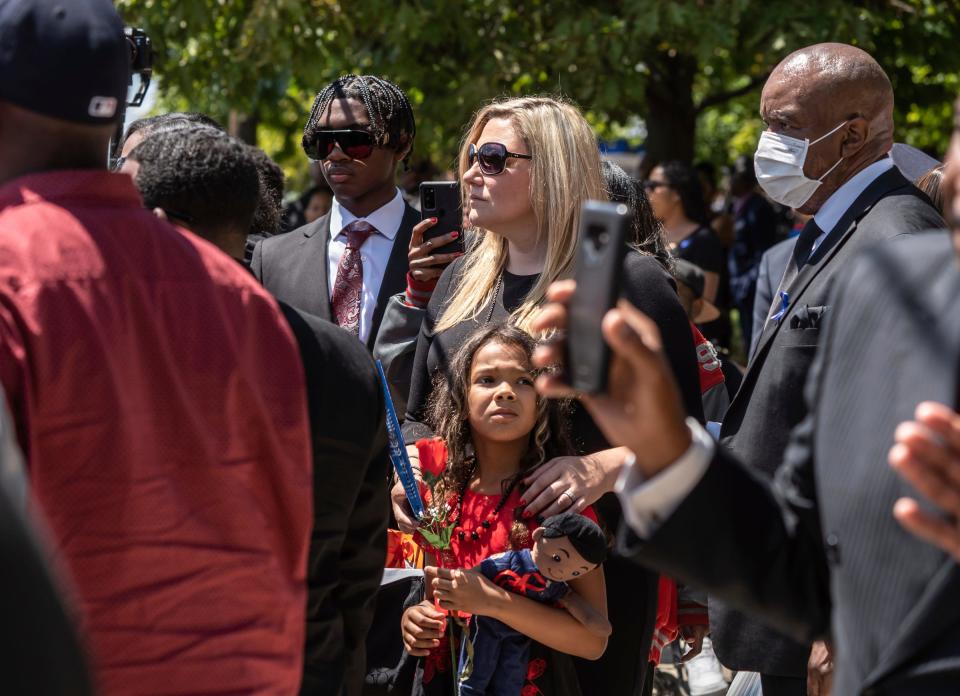 Kristine Courts and her daughter Devyn Courts, 9, stand with others as the casket carrying her husband Detroit Police Officer Loren Courts on Monday, July 18, 2022, is carried out to a hearse at the end of his funeral at Greater Grace Temple in Detroit.