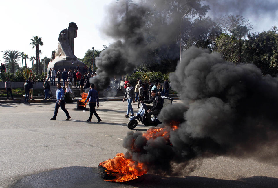 Supporters of ousted leader Mohammed Morsi burn tires during a protest in Nahda Square, near Cairo University in Giza, Egypt, Sunday, Jan. 12, 2014. With a presidential run by Egypt’s powerful military chief seeming more likely by the day, this week’s two-day constitution referendum, to be held amid a massive security force deployment, is widely seen as a vote of confidence in the regime he installed last summer. (AP Photo/Heba Elkholy)