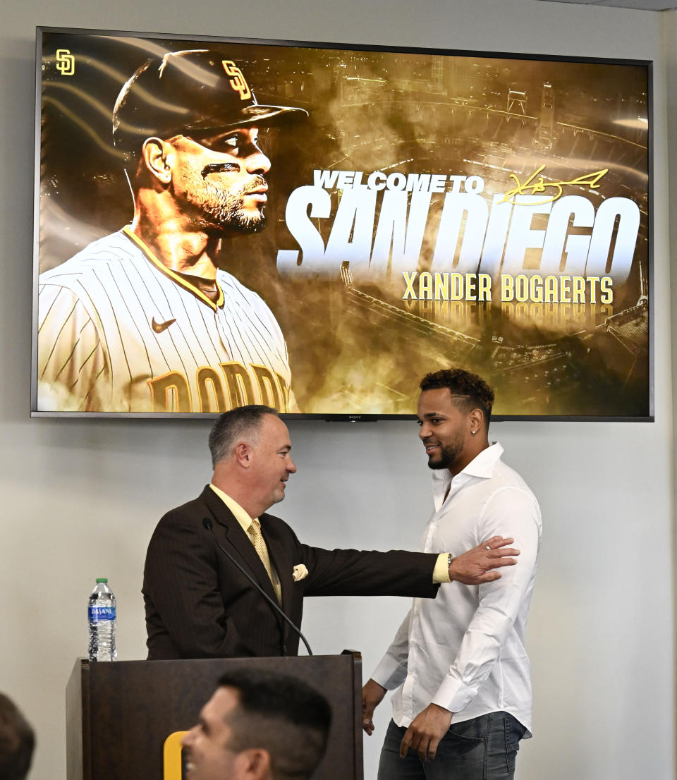 San Diego Padres' Xander Bogaerts, right, is welcomed by announcer Don Orsillo as he arrives at a news conference held to announce that his $280 million, 11-year contact with the Padres has been finalized, Friday, Dec. 9, 2022, in San Diego. (AP Photo/Denis Poroy)