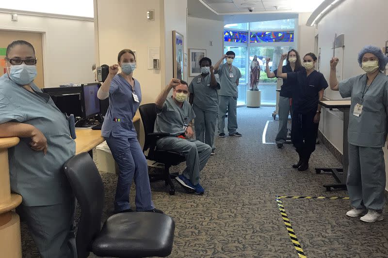 Nurses at Providence Saint John's Health Center in Santa Monica, Calif., on April 9, raise their fists in solidarity after telling managers they can't care for COVID-19 patients without N95 respirator masks to protect themselves.(Lizabeth Baker Wade/AP) 