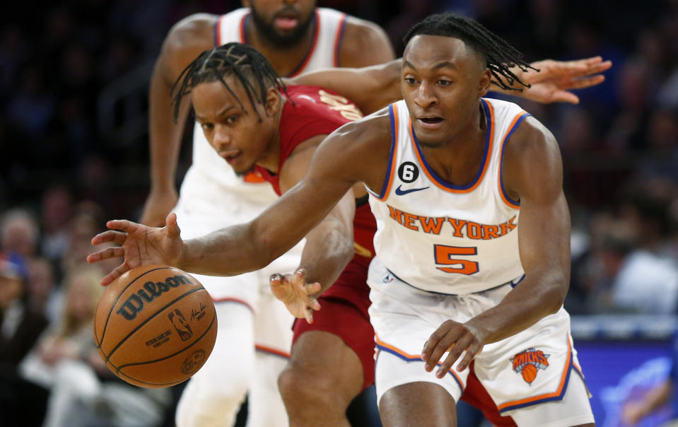 New York Knicks guard Immanual Quickley (5) grabs the ball in front of Cleveland Cavaliers guard Isaac Okoro during the second half of an NBA basketball game, Sunday, Dec. 4, 2022, in New York. The Knicks won 92-81. (AP Photo/John Munson)
