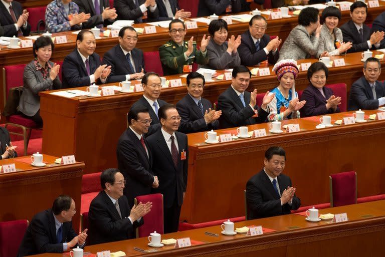 Delegates applaud as China's outgoing premier Wen Jiabao (C-R) shakes hands with newly elected premier Li Keqiang (C-L) next to President Xi Jinping (lower R) during a session of the National People's Congress (NPC) at the Great Hall of the People in Beijing on March 15, 2013. China's parliament installed Li as premier in a final step of a landmark power transition