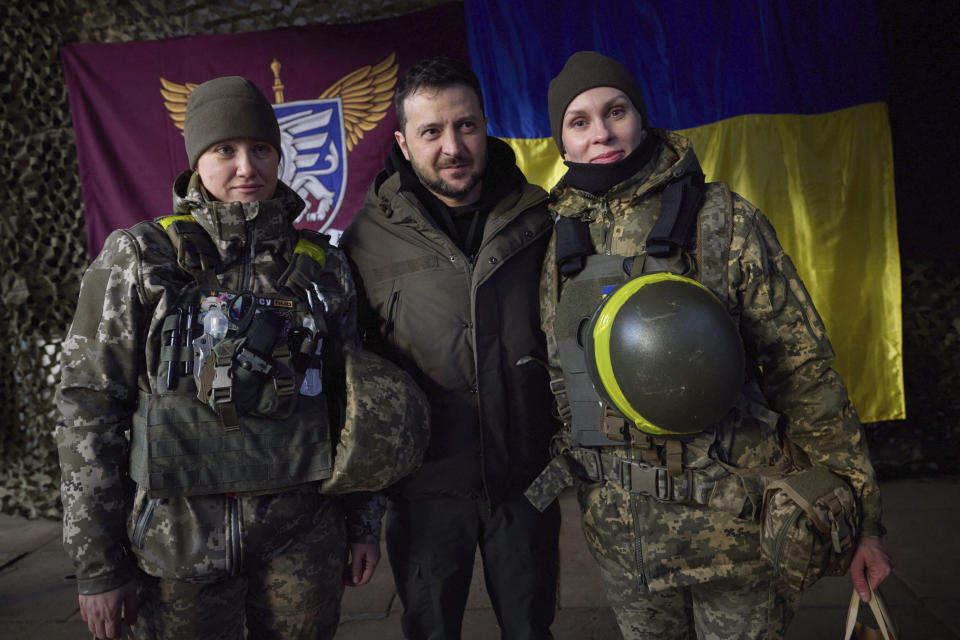 In this photo provided by the Ukrainian Presidential Press Office, Ukrainian servicewomen pose for a photo with President Volodymyr Zelenskyy, center, during his visit to Sloviansk, Donbas region, Ukraine, Tuesday, Dec. 6, 2022. (Ukrainian Presidential Press Office via AP)