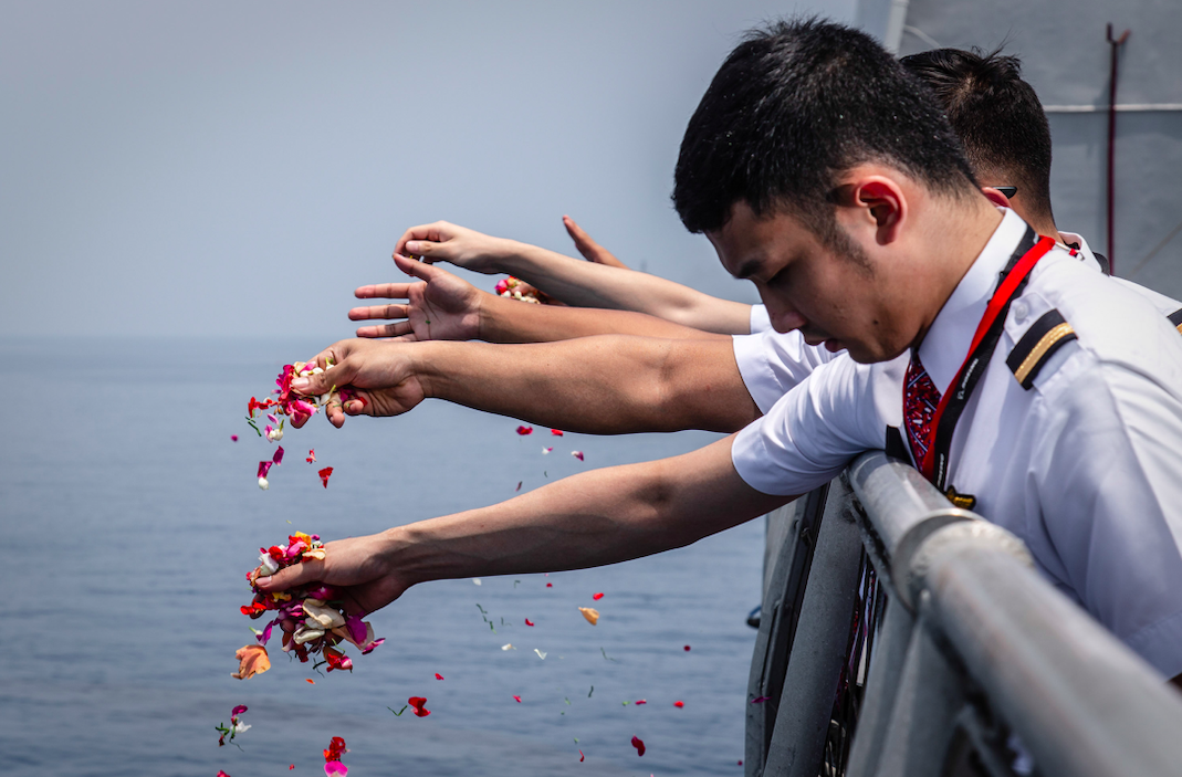 <em>Colleagues of victims of Lion Air flight JT 610 throw flowers on deck of Indonesian Navy ship KRI Banjarmasin at the site of the crash in Karawang, Indonesia (Getty)</em>