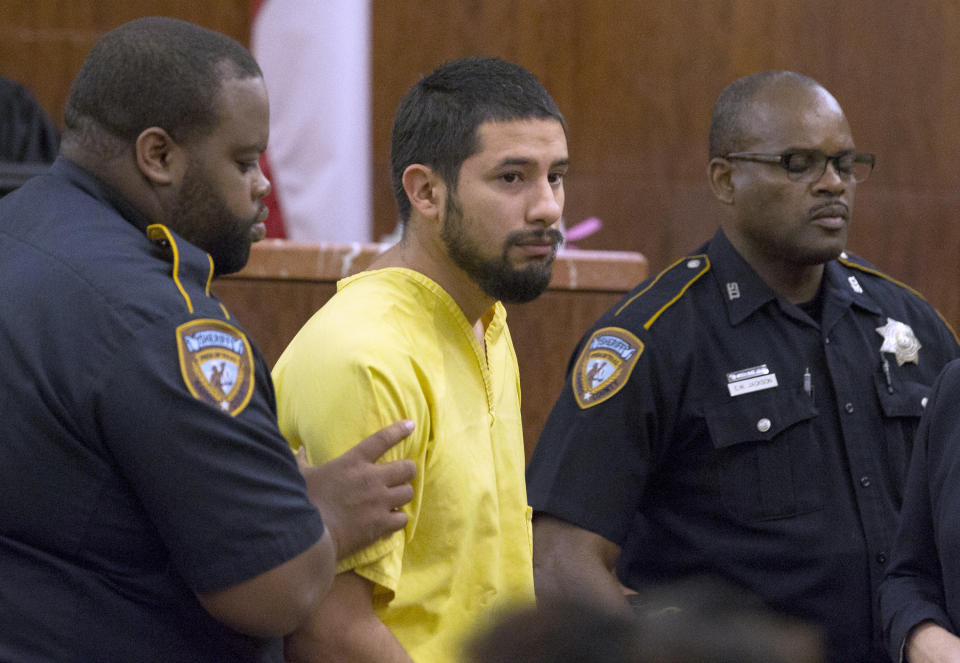 Arturo Solis, 25, is taken away with no bond after he appeared before Judge Danilo Lacayo at the 182nd Judicial District Court at Harris County Criminal Justice Center on Monday, Dec. 9, 2019, in Houston. Solis is accused of shooting and killing Houston Police Department Sgt. Christopher Brewster on Saturday. (Yi-Chin Lee/Houston Chronicle via AP)