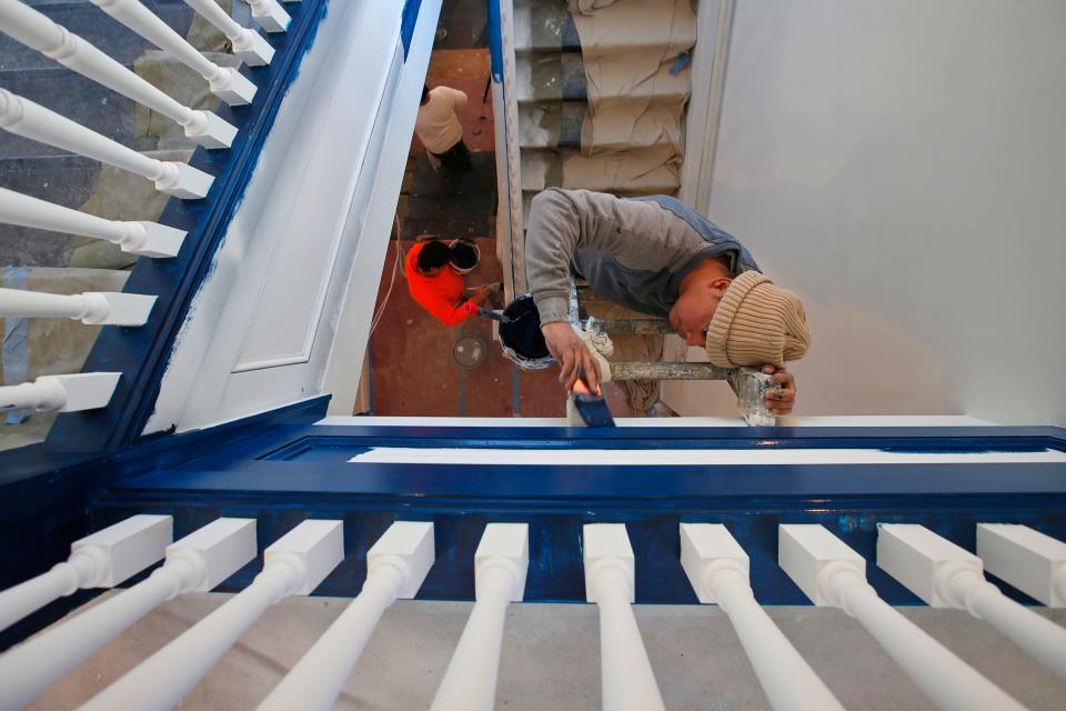 Painters put the final touches on the stairwell at the former Holy Family High School building which has been converted into housing.
(Credit: PETER PEREIRA/The Standard-Times/FILE)