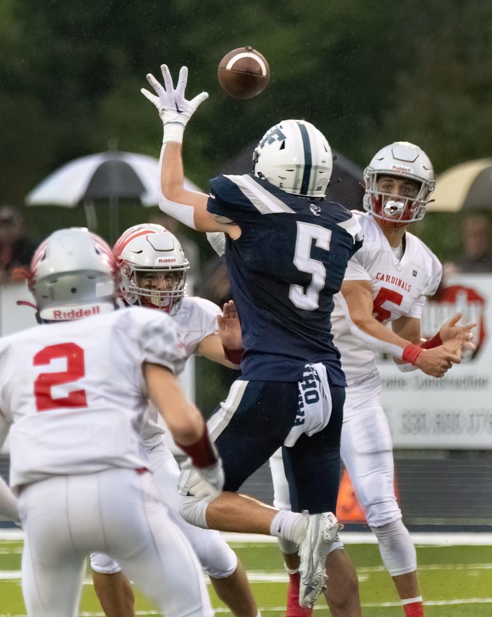 Sandy Valley quarterback Nick Petro completes a pass to Jason Morris (2) past Fairless defender Gio Moore, Thursday, Aug. 17, 2023.