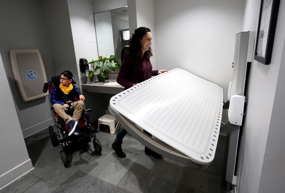 Kim Boulter folds up Franklin Park Conservatory's new changing table after she and her son, Aiden, 9 years old at the time, who is developmentally disabled, posed for a portrait.