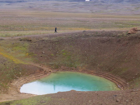 A woman walks past the smaller crater of the Krafla volcano near Reykjahlid, Iceland, September 19, 2015. Picture taken September 19, 2015. REUTERS/Lefteris Karagiannopoulos