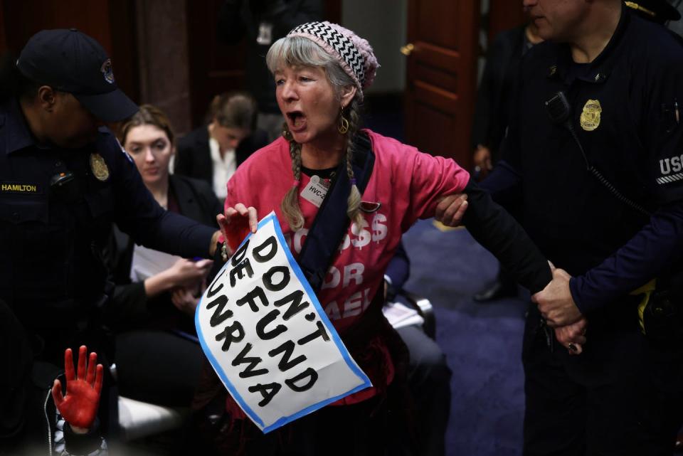 A protester is removed by members of the U.S. Capitol Police during a House hearing on Jan. 30, 2024. <a href="https://www.gettyimages.com/detail/news-photo/protester-leslie-angeline-of-codepink-is-removed-by-members-news-photo/1973436909?adppopup=true" rel="nofollow noopener" target="_blank" data-ylk="slk:Alex Wong/Getty Images;elm:context_link;itc:0;sec:content-canvas" class="link ">Alex Wong/Getty Images</a>