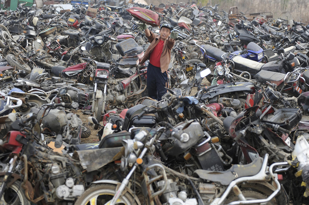 A laborer disassembles motorcycles at a recycling factory in Hefei, Anhui province, China in 2009. (Photo: Jianan Yu/Reuters)