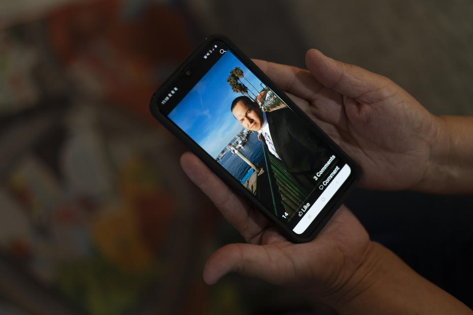 Ana Sandoval, mother of Eyvin Hernandez, a Los Angeles attorney who has been detained for five months in Venezuela, shows a photo of Hernandez in Compton, Calif., Monday, Aug. 29, 2022. The Los Angeles attorney detained for five months in Venezuela is pleading for help from the Biden administration, saying in a secretly recorded jailhouse message that he feels forgotten by the U.S. government as he faces criminal charges at the hands of one of the nation's top adversaries. (AP Photo/Jae C. Hong)