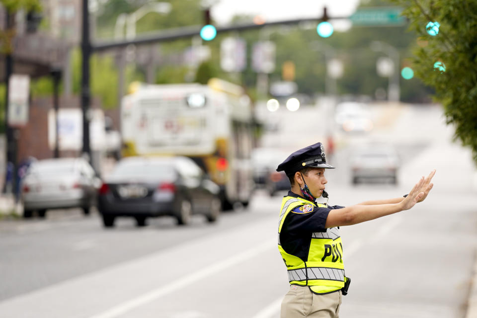 In this Sept. 9, 2020, photo a cadet in the Baltimore Police Academy directs traffic during an on the field class session in Baltimore. (AP Photo/Julio Cortez)