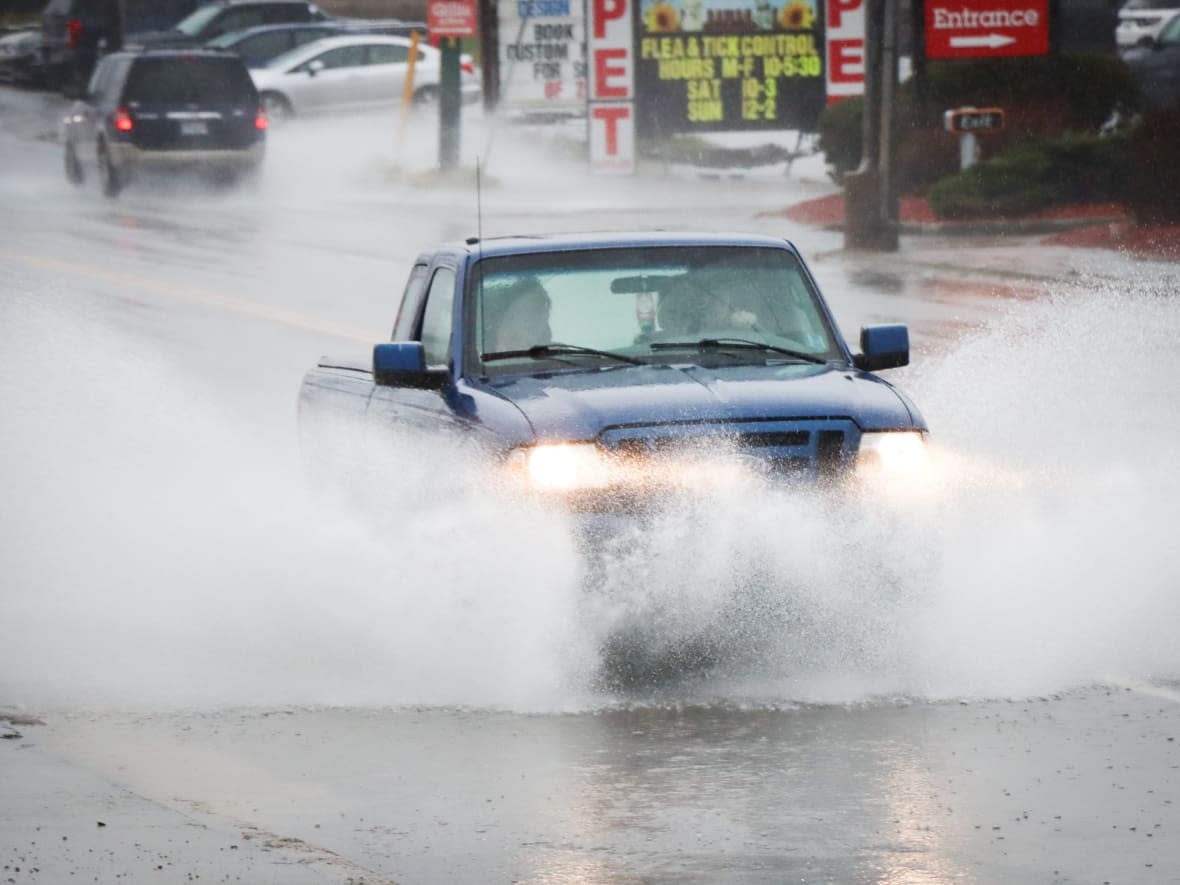 A truck plows through a puddle on Kings Road, Sydney River, N.S., on Nov. 23. Sydney and the surrounding area are expecting up to 50 millimetres of rain. (Tom Ayers/CBC - image credit)