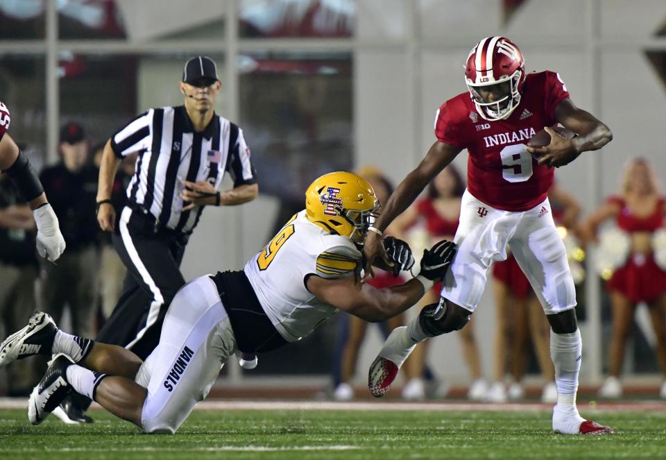 Sep 11, 2021; Bloomington, Indiana, USA; Indiana Hoosiers quarterback Michael Penix Jr. (9) evades a tackle against Idaho Vandals defensive lineman Noah Elliss (99) during the second quarter at Memorial Stadium. Mandatory Credit: Marc Lebryk-USA TODAY Sports