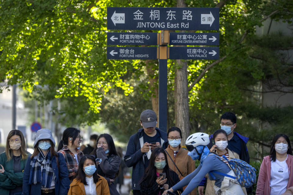 Commuters wait at an intersection in the central business district during the morning rush hour in Beijing, Tuesday, April 18, 2023. China’s economy grew 4.5% in the first quarter of the year, boosted by increased consumption and retail sales, after authorities abruptly abandoned the stringent "zero-COVID" strategy. (AP Photo/Mark Schiefelbein)