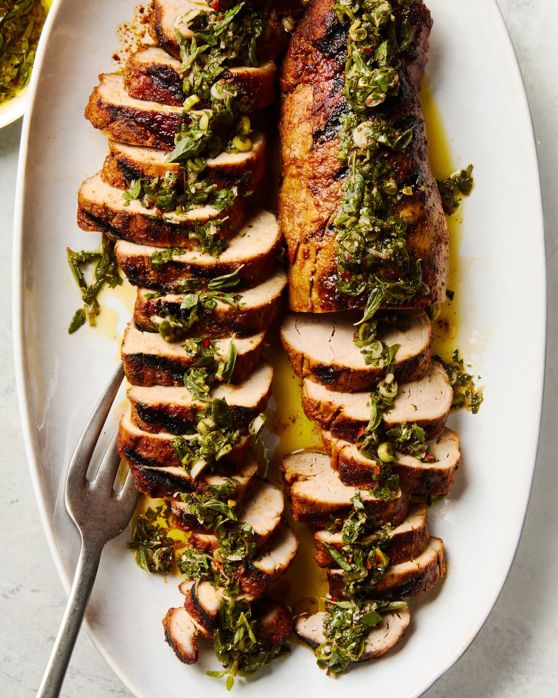 grilled pork tenderloin sliced and topped with a fresh herb sauce