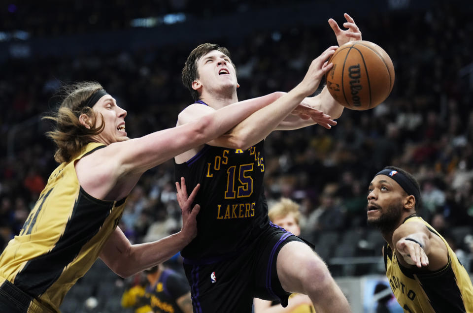 Toronto Raptors forward Kelly Olynyk, left, knocks the ball away from Los Angeles Lakers guard Austin Reaves (15) as Raptors forward Bruce Brown watches during the second half of an NBA basketball game Tuesday, April 2, 2024, in Toronto. (Frank Gunn/The Canadian Press via AP)
