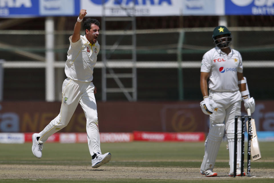 Australia's Mitchell Starc, left, celebrates after taking the wicket of Pakistan Azhar Ali, right, during the third day of the second test match between Pakistan and Australia at the National Stadium in Karachi, Pakistan, Monday, March 14, 2022. (AP Photo/Anjum Naveed)