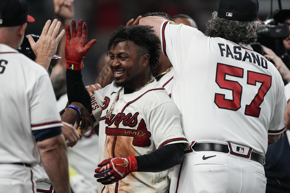 CORRECTS TO THREE-RIN HOME RUN NOT TWO-RUN HOME RUN - Atlanta Braves' Ozzie Albies, center, celebrates after hitting a winning three-run home run in the 10th inning of a baseball game against the New York Mets, Thursday, June 8, 2023, in Atlanta. (AP Photo/John Bazemore)