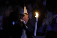 Pope Francis holds a candle as he presides over a solemn Easter vigil ceremony in St. Peter's Basilica at the Vatican, Saturday, April 21, 2019. (AP Photo/Gregorio Borgia)