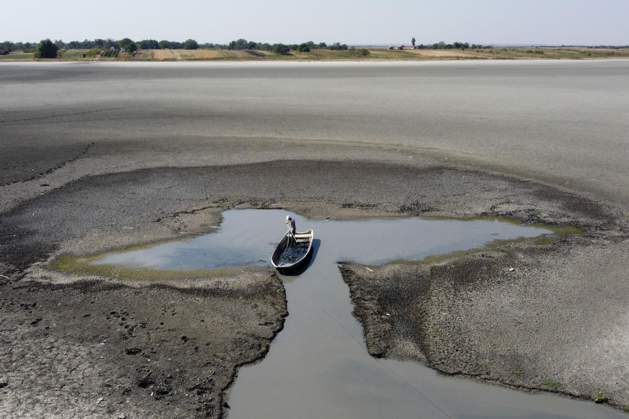 A man collects mud that is used in medical therapy at the dried out Rusanda salty lake, near Melenci, Serbia, Wednesday, Sept. 4, 2024. Experts say the summer of 2024 in the Balkans was the hottest since measurements started more than 130 years ago. (AP Photo/Darko Vojinovic)