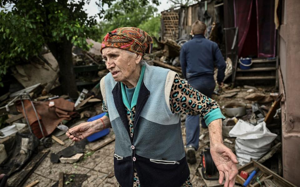 An elderly woman stands outside her destroyed home after it was hit by a Russian missile in the city of Bakhmut in the eastern Ukrainian region of Donbas - ARIS MESSINIS/AFP