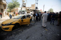 People gather at the site of car bomb attack near a government office in Karkh district in Baghdad. REUTERS/Khalid al-Mousily