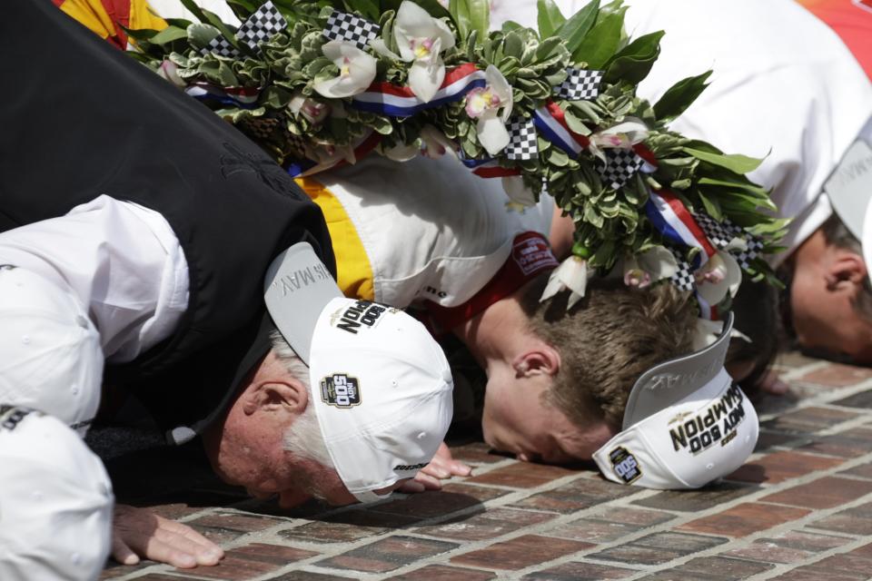 Roger Penske and Josef Newgarden kiss the bricks after Newgarden won the Indianapolis 500 auto race at Indianapolis Motor Speedway, Sunday, May 28, 2023, in Indianapolis. (AP Photo/Rob Baker)