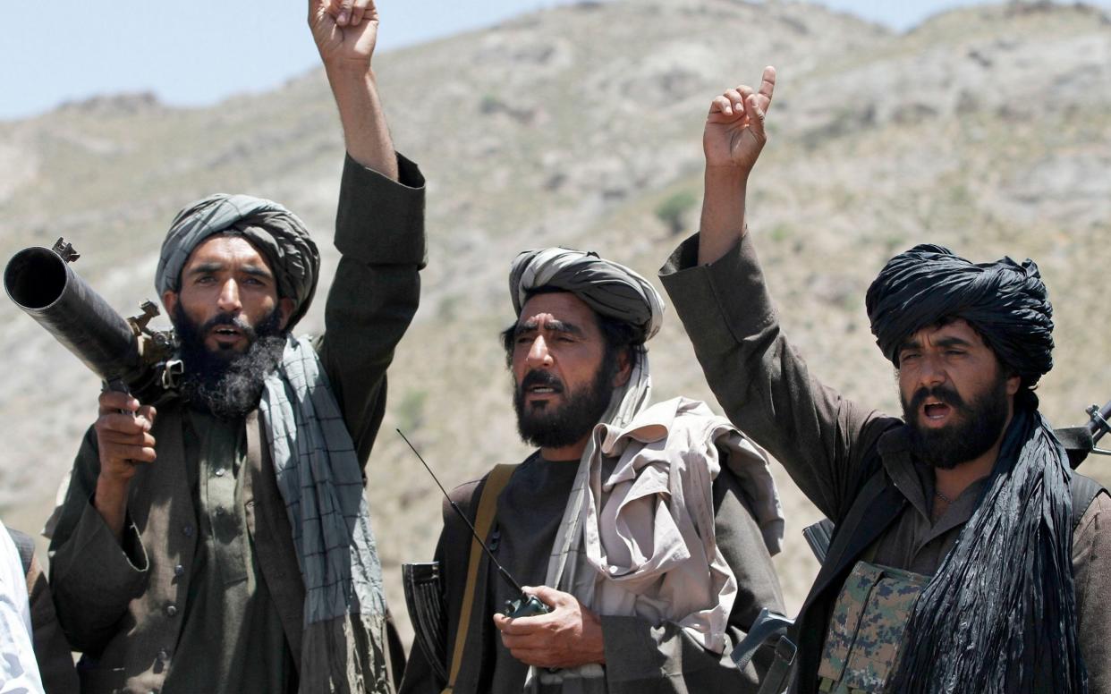 Taliban fighters react to a speech by their senior leader in the Shindand district of Herat province - AP