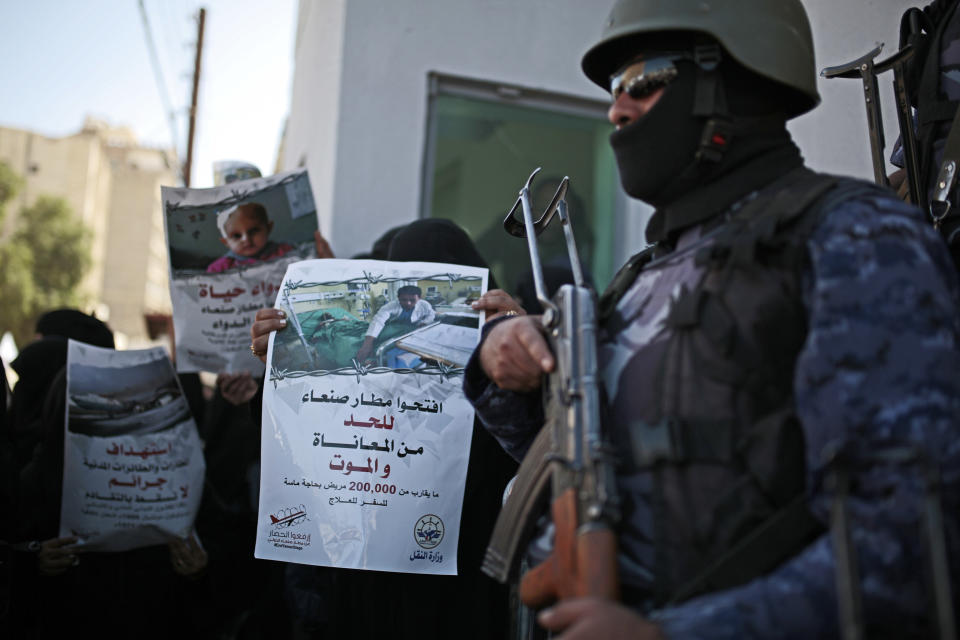 FILE - In this Dec. 10, 2018 file photo, a Yemeni woman holds a banner with Arabic that reads: "Open Sanaa airport to limit the suffering and deaths!" during a protest calling for the reopening of Sanaa airport to receive medical aid, in front of the U.N. offices in Sanaa, Yemen. The Norwegian Refugee Council and CARE have slammed the Saudi-led coalition for its closure of the airport in Yemen's capital, saying this has prevented thousands of sick civilians from traveling abroad for urgent medical treatment, saying the Sanaa airport's three-year closure has amounted to a "death sentence" for many sick Yemenis. The two aid groups appealed late Monday, Aug 5, 2019 on Yemen's warring parties to come to an agreement to reopen the airport for commercial flights to "alleviate humanitarian suffering caused by the closure." (AP Photo/Hani Mohammed, File)