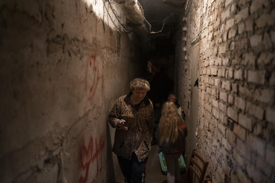 Helena walks inside the basement of a residential building during a Russian attack in Lyman, Ukraine, Tuesday, April 26, 2022. The 60-year-old woman says it's a very difficult moment. All residents of the building are living in the basement. "They hit us endlessly with rockets", she adds. Russia pounded eastern and southern Ukraine on Tuesday as the U.S. promised to "keep moving heaven and earth" to get Kyiv the weapons it needs to repel the new offensive, despite Moscow's warnings that such support could trigger a wider war. (AP Photo/Leo Correa)