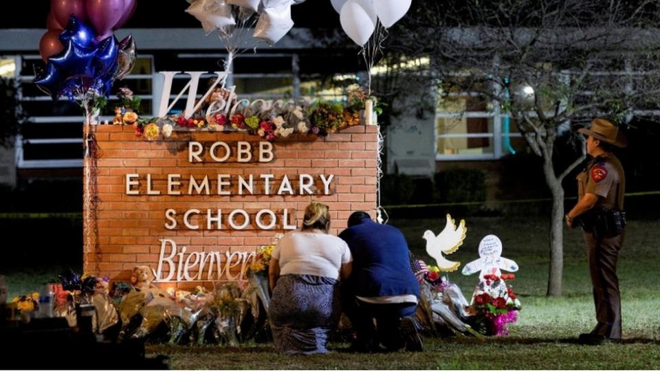 Stephanie y Michael Chavez de San Antonio presentan sus respetos en un memorial improvisado afuera de la escuela primaria Robb.