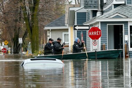 People row a boat in a flooded residential area in Gatineau, Quebec, Canada, May 7, 2017. REUTERS/Chris Wattie