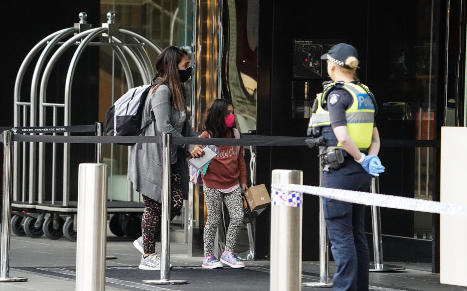 Recently arrived overseas travellers get off their bus and wait to check in at the Crown Promenade Hotel in Melbourne for quarantine. Source: AAP
