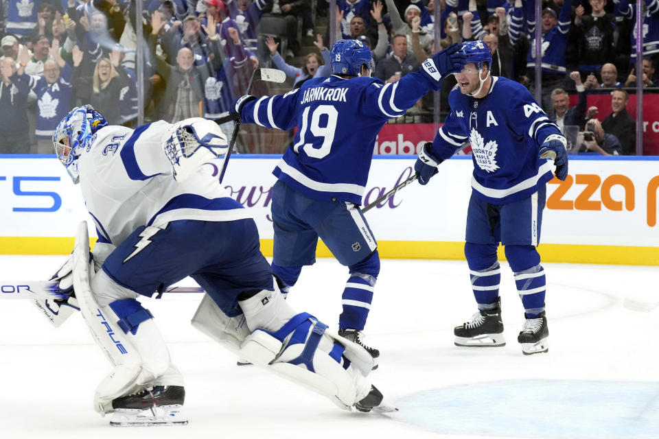 Toronto Maple Leafs center Calle Jarnkrok (19) celebrates with defenseman Morgan Rielly (44) after scoring the winning goal as Tampa Bay Lightning goaltender Jonas Johansson (31) skates off the ice at an NHL hockey game in Toronto, Monday, Nov. 6, 2023. (Chris Young/The Canadian Press via AP)