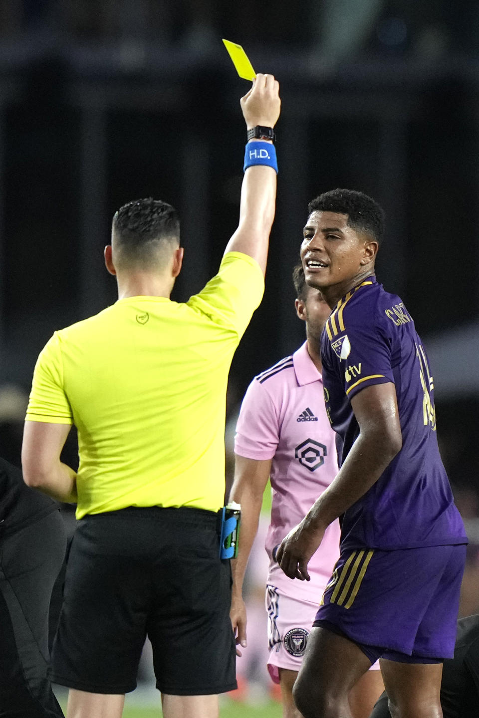 Orlando City midfielder Wilder Cartagena, right, is given a yellow card by an official during the first half of an MLS soccer match against Inter Miami, Saturday, May 20, 2023, in Fort Lauderdale, Fla. (AP Photo/Lynne Sladky)