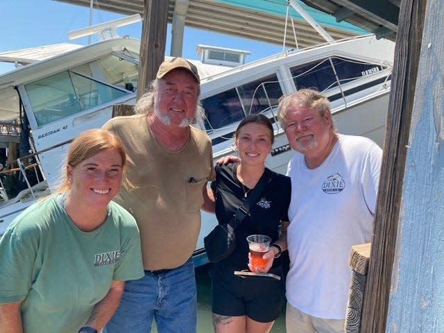 Eddie Kane, second from left, posing for a photo in front of his boat at Bonita Bill's on Fort Myers Beach. "They in the restaurant and asked me if that was my boat on the dock and I told them it was," Kane said. "They asked if I could take a photo with them."