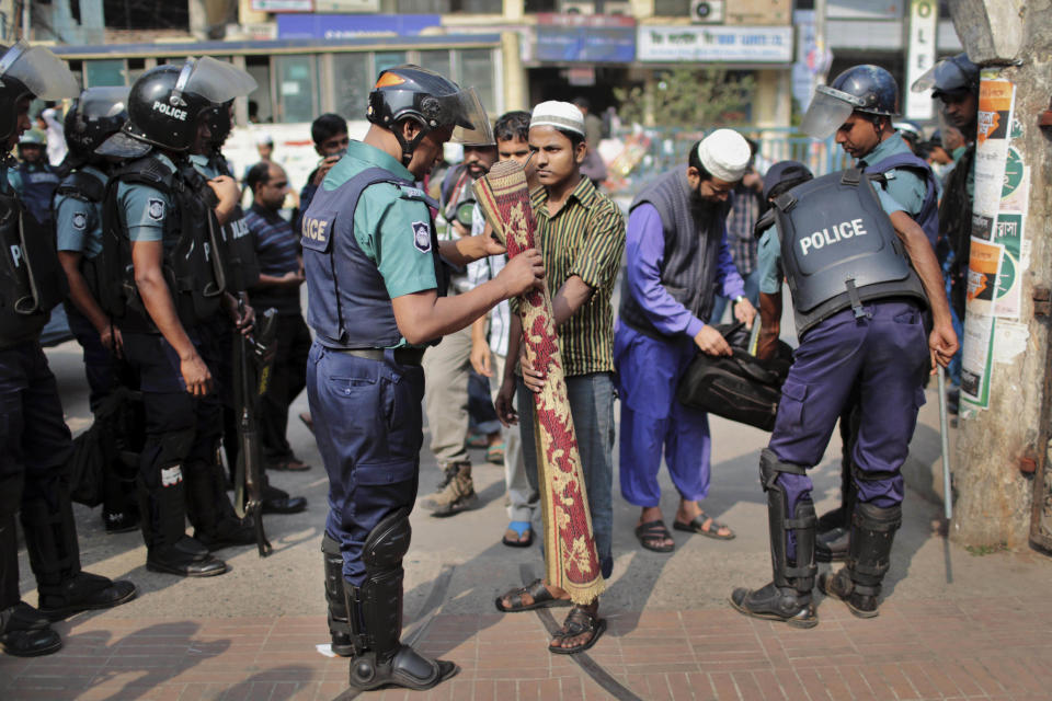 La policía de Bangladesh registra a feligreses que visitan la mezquita nacional para las oraciones del viernes durante un bloqueo convocado por los partidos de la oposición antes de las elecciones generales en Daca, capital de Bangladesh, el viernes 3 de enero del 2014. (Foto AP/A.M. Ahad)