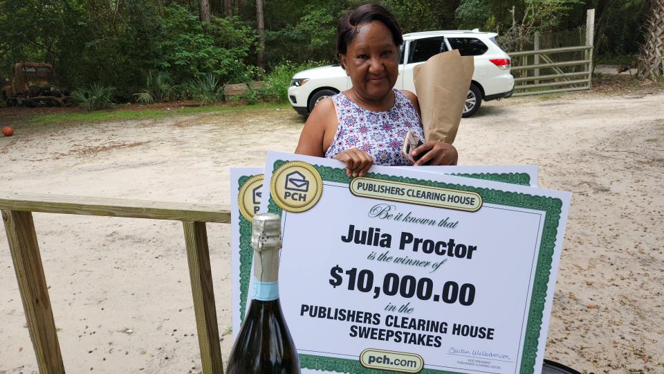 Julia Proctor smiles as she holds a $10,000 check she received on her birthday, Friday, Sept. 23, 2022.