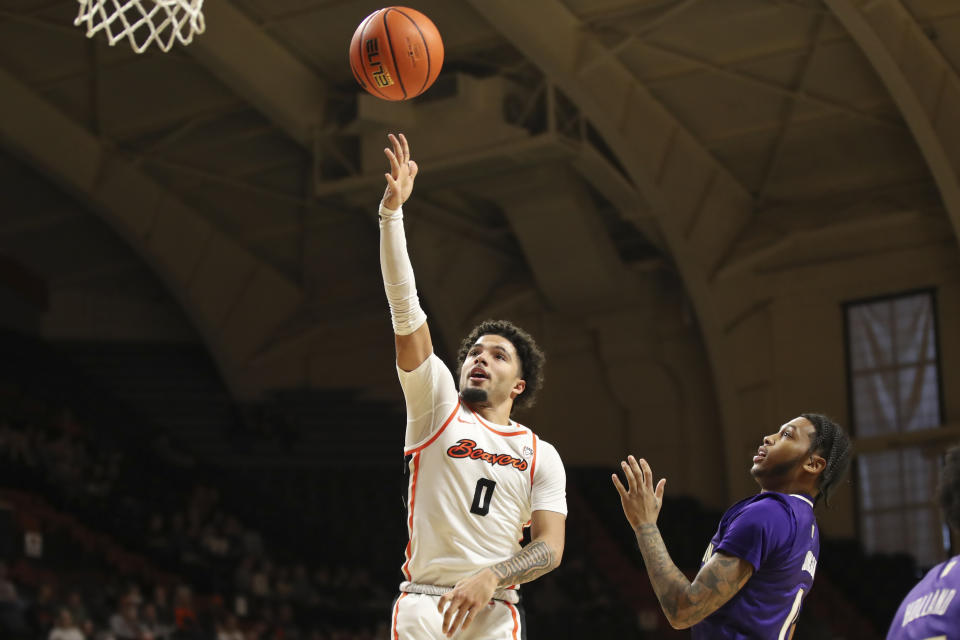 Oregon State guard Jordan Pope (0) shoots past Washington guard Koren Johnson (0) during the first half of an NCAA college basketball game Saturday, Feb. 10, 2024, in Corvallis, Ore. (AP Photo/Amanda Loman)