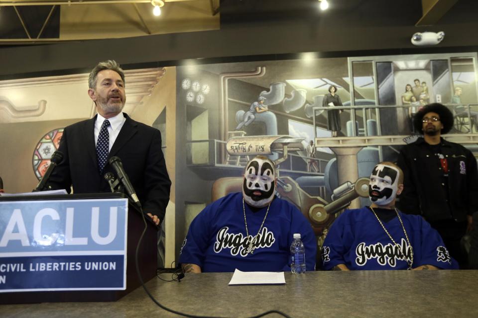 Michael J. Steinberg, legal director for the ACLU of Michigan addresses the media as Joseph Bruce aka Violent J, center, and Joseph Utsler aka Shaggy 2 Dope, members of the Insane Clown Posse listen in Detroit, Wednesday, Jan. 8, 2014. The rap metal group sued the U.S. Justice Department on Wednesday over a 2011 FBI report that describes the duo's devoted fans, the Juggalos, as a dangerous gang, saying the designation has tarnished their fans' reputations and hurt business. The American Civil Liberties Union filed the lawsuit in Detroit federal court on behalf of the group's two members. (AP Photo/Carlos Osorio)