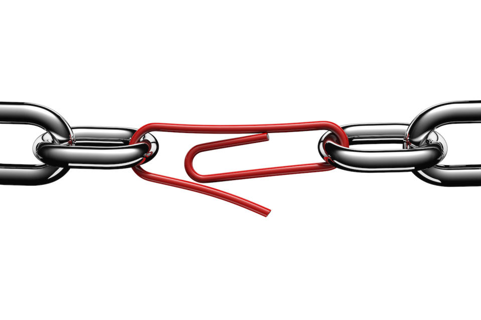 Steel chain links connected in the middle by a red paperclip, on white background, cut out