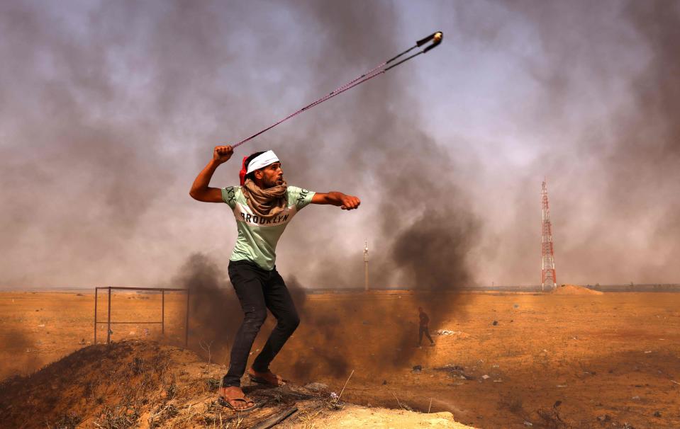 A Palestinian throws rocks earlier todayAFP via Getty Images