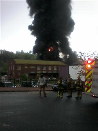 Emergency personnel look at flames and black smoke from a CSX Corp train carrying crude oil that derailed and burst into flames in downtown Lynchburg, Virginia, April 30, 2014. REUTERS/WSET/Handout via Reuters