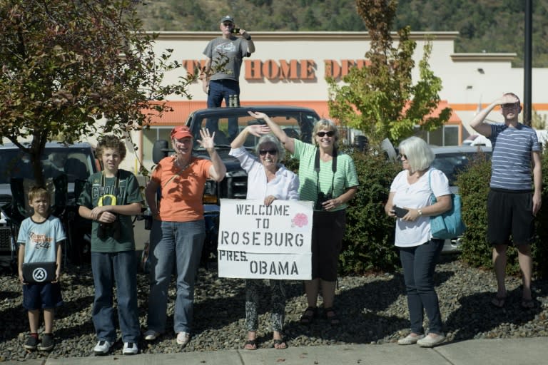 People watch as a motorcade with US President Barack Obama passes on October 9, 2015 in Roseburg, Oregon