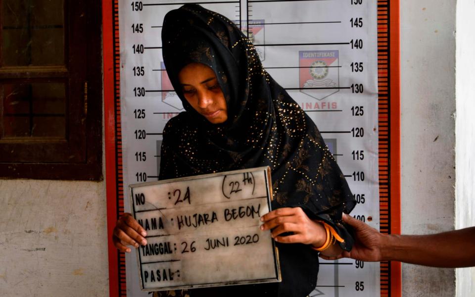 A Rohingya woman from Myanmar goes through an identification procedure by Indonesia police - CHAIDEER MAHYUDDIN/AFP