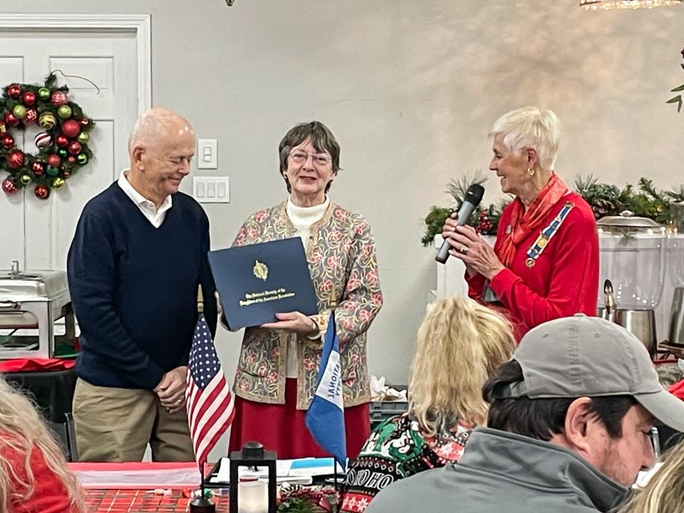 Chuck and Shana Fair receive the Community Service Award from Regent Sharon Miller, right, of the Anna Asbury Stone Chapter of the Daughters of the American Revolution.
