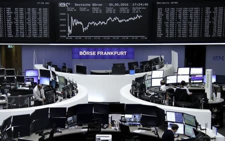 Traders work at their desks in front of the German share price index, DAX board, at the stock exchange in Frankfurt, Germany, May 30, 2016. REUTERS/Staff/Remote