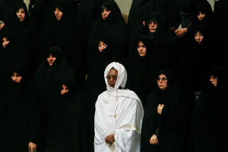 FILE PHOTO: A woman from an African Islamic country (in white) stands among Iranian women during the national anthem of Iran at the opening session of the 8th Islamic Conference Summit in Tehran's new conference building on December 9. REUTERS/Yannis Behrakis/File photo